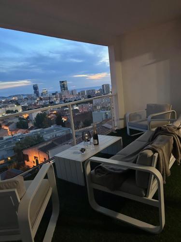 Cette chambre dispose d'un balcon avec une table et des verres à vin. dans l'établissement Appartement standing tout confort vue mer, à Marseille