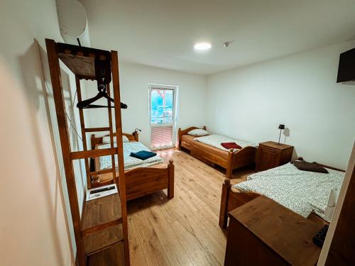 a room with two bunk beds and a ladder at Wektor Hostel in Ługów