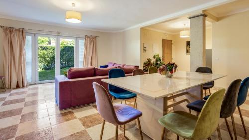a living room with a couch and a table and chairs at Villa Girassol in Vilamoura