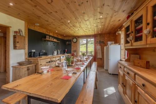 une grande cuisine en bois avec une grande table en bois dans l'établissement Chalet du Pradel, aux Estables
