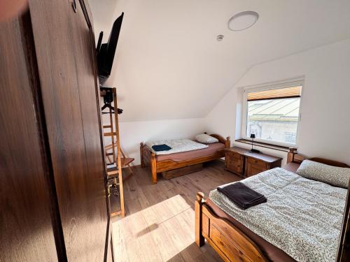 a small room with two beds and a window at Wektor Hostel in Ługów