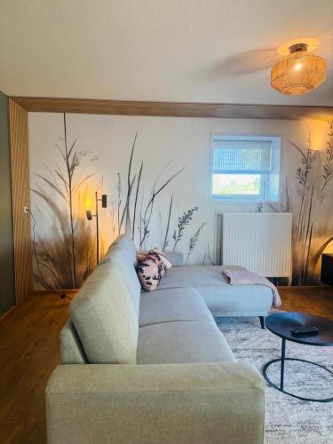a living room with a couch and a painting on the wall at Vakantiehuis De Meierij in Schijndel