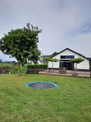 a pond in the middle of a yard with a house at Vakantiehuis De Meierij in Schijndel