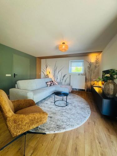 a living room with a couch and a table at Vakantiehuis De Meierij in Schijndel
