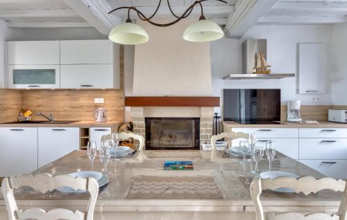 une cuisine avec une table et des chaises ainsi qu'une cheminée dans l'établissement Maison Proche Mer, à Créances