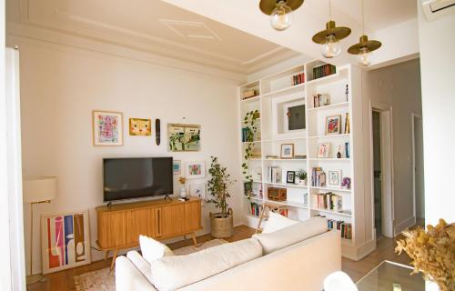 a living room with a white couch and a television at Artist's Retreat near the Riverside with AC in Lisbon