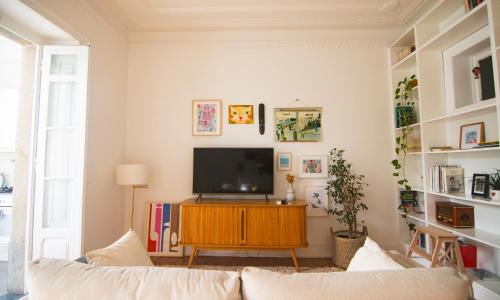 a living room with a television on a wooden cabinet at Artist's Retreat near the Riverside with AC in Lisbon