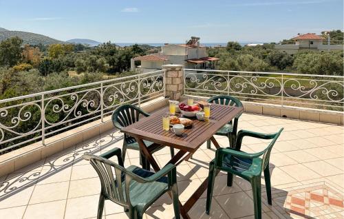 a wooden table with chairs and a bowl of fruit on a balcony at Gorgeous Home In Lagonisi With Wifi in Lagonissi