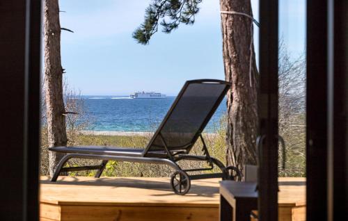 Una silla negra sentada en un porche con vista al océano. en Cozy Home In Knebel With Sauna, en Ørby