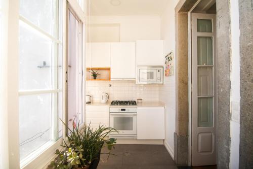 a small kitchen with white appliances and a window at Artist's Retreat near the Riverside with AC in Lisbon