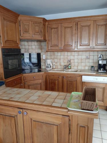 une cuisine avec des armoires en bois et un comptoir dans l'établissement Idéal , Plein centre-ville tout confort, à Espalion