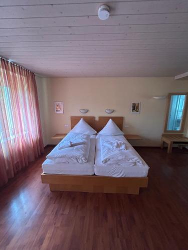 a bedroom with a bed with white sheets and pillows at Bad Bruckhaus Erlebnishotel in Waldshut-Tiengen
