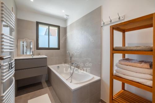 une salle de bain avec une baignoire, un lavabo et un miroir dans l'établissement Villa Atlantique, à Le Touquet-Paris-Plage