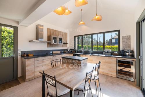 une cuisine avec une grande table et des chaises en bois dans l'établissement Villa Atlantique, à Le Touquet-Paris-Plage
