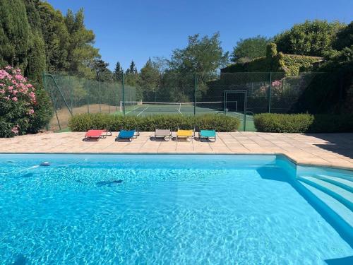 une piscine avec des chaises et un court de tennis dans l'établissement Villa dans les Corbières avec piscine et tennis, à Ferrals-lès-Corbières
