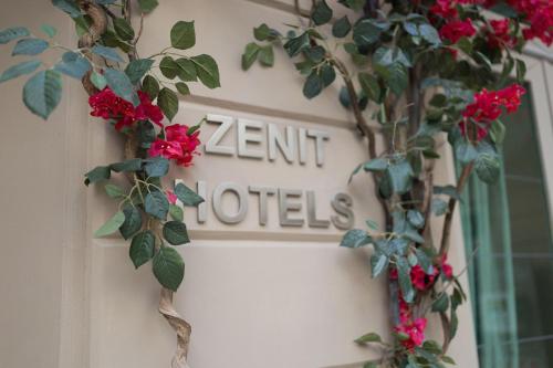 a sign on a door with red flowers on it at Hotel Zenit Budapest Palace in Budapest