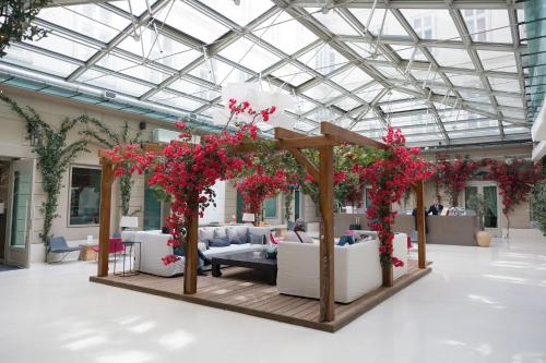 a room filled with furniture and red flowers at Hotel Zenit Budapest Palace in Budapest
