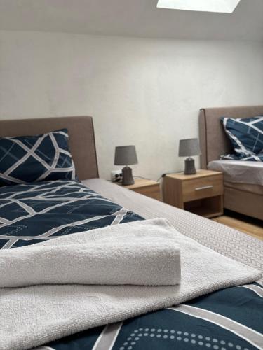 a bedroom with two beds and two lamps on tables at Apartment La Casa in Pluzine