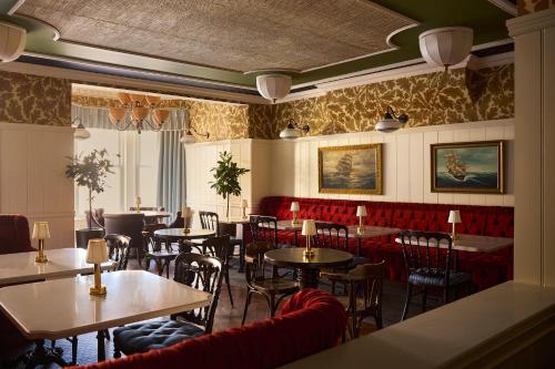 a restaurant with tables and chairs in a room at Portrush Adelphi in Portrush
