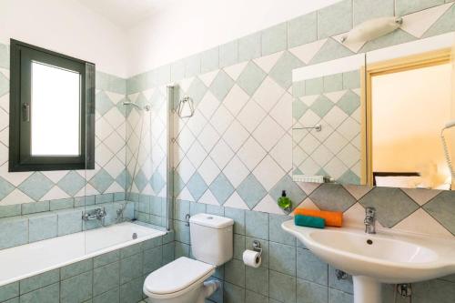 a bathroom with a toilet and a sink and a tub at Villa Thalassia by Villa Plus in Kassiopi