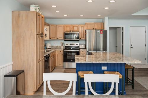 a kitchen with wooden cabinets and a blue island at Partial Oceanview 4BR,3BA, Sleeps 12 Steps to Beach Oak Island in Oak Island