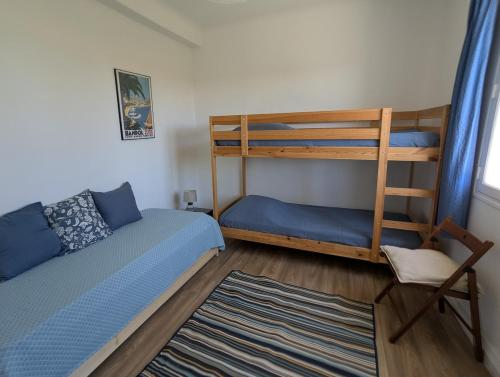 une chambre avec deux lits superposés et un tapis dans l'établissement Haut de villa à 10 minutes à pied de la plage, parking, jardin, à Bandol