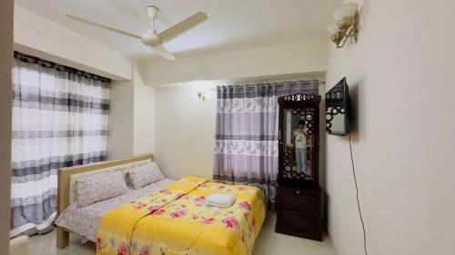 a bedroom with a bed and a clock in it at Baridhara Sweet Home in Dhaka