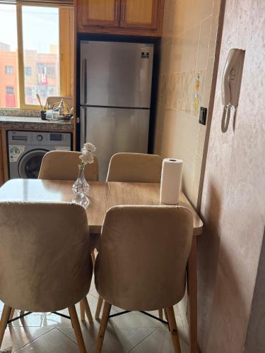 a kitchen with a table with chairs and a refrigerator at Julie's Private Apartment in Marrakech