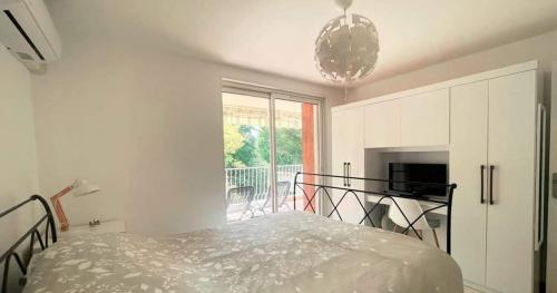 une chambre blanche avec un lit et une fenêtre dans l'établissement Les Lecques 2 room apartment with terrace and parking, aux Lecques