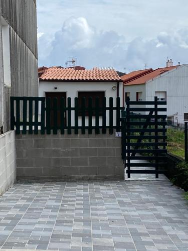 a black fence in front of a house at A Casiña de Tivo in Fisterra