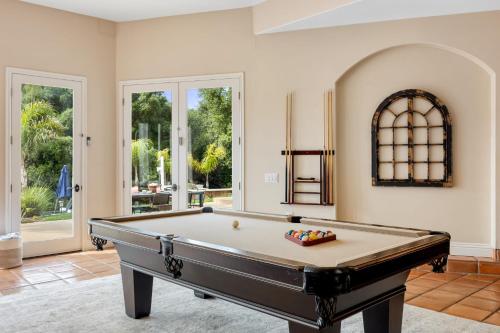 a pool table in a large room with windows at Grapevine by AvantStay Secluded 5BR Villa 4 Acres of Vineyards Avo Groves in Temecula