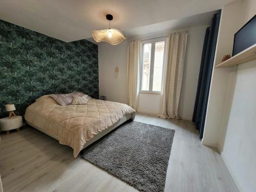 une chambre avec un lit et une grande fenêtre dans l'établissement Maison au coeur du village de Sérignan 3km de la mer, à Sérignan