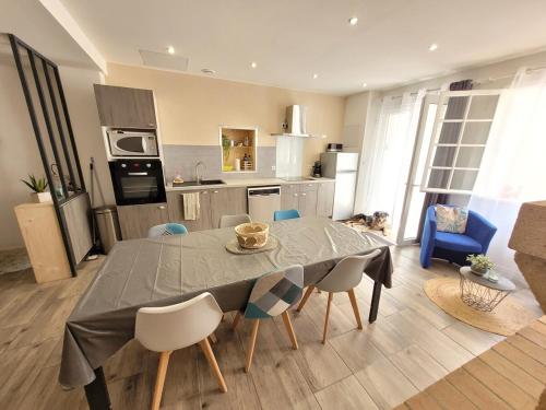 une cuisine avec une table et des chaises dans une pièce dans l'établissement Maison au coeur du village de Sérignan 3km de la mer, à Sérignan