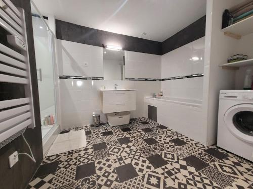 La salle de bains est pourvue de carrelage noir et blanc. dans l'établissement Maison au coeur du village de Sérignan 3km de la mer, à Sérignan