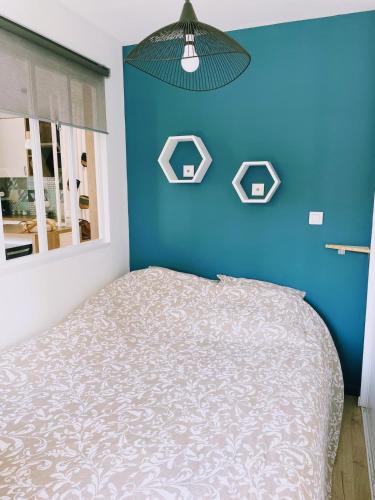 - une chambre bleue avec un lit et un mur bleu dans l'établissement Jeannette's House, à Magny-le-Hongre