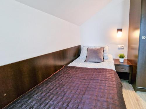 a large bed in a room with a wooden headboard at Villa Sarema in Chłopy