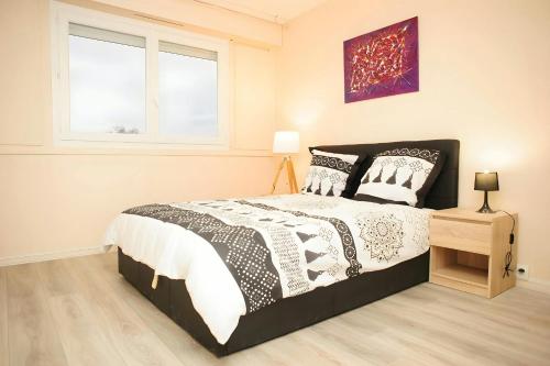 une chambre avec un lit noir et blanc et une fenêtre dans l'établissement COSY HOUSE Créteil 3 pièces, à Créteil