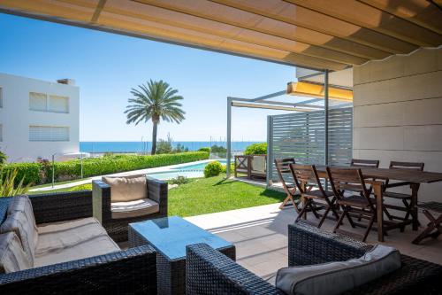 a patio with a table and chairs and a view of the ocean at AT051 A pocos metros de la playa, equipamiento completo, piscina comunitaria in Torredembarra