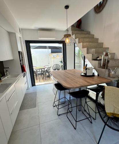 une cuisine et une salle à manger avec une table et un escalier dans l'établissement Maison de village rénovée !, au Grau-du-Roi