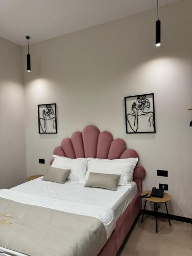 a bedroom with a large bed with a pink headboard at Villa La Mer Durres in Durrës