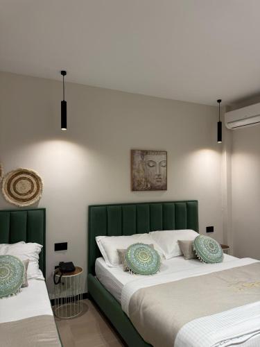 two beds with green headboards in a bedroom at Villa La Mer Durres in Durrës