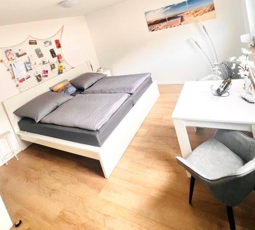 グラール・ミューリッツにあるFerienwohnung Dünengrasのベッドと机と椅子のある寝室