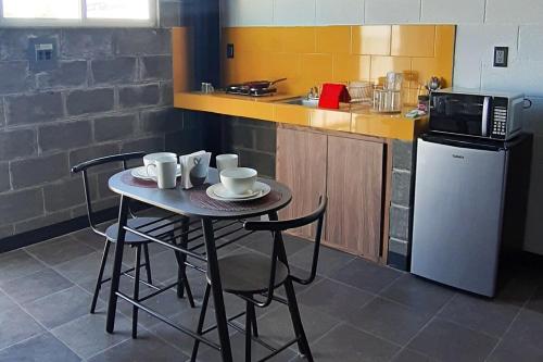 a small kitchen with a table with chairs and a microwave at GRAN DEPTO EJECUTIVO CERCA de EXPLANADA in Pachuca de Soto