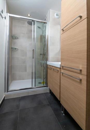 une salle de bain avec une douche avec une porte vitrée dans l'établissement Large and beautiful apartment with panoramic sea views, à Marseille