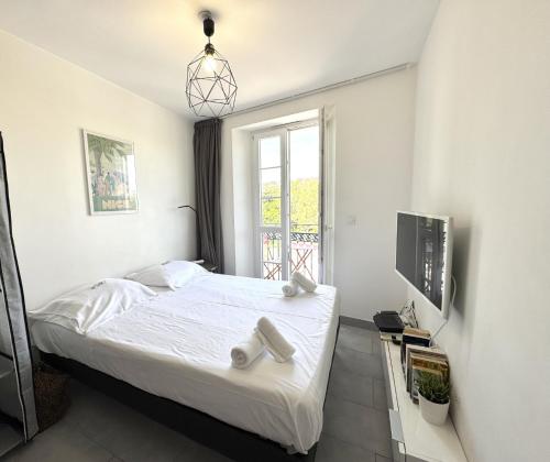 une chambre blanche avec un lit et une fenêtre dans l'établissement ApartHotel riviera - Balcon Jean Jaures 2 - Place Massena - Old, à Nice