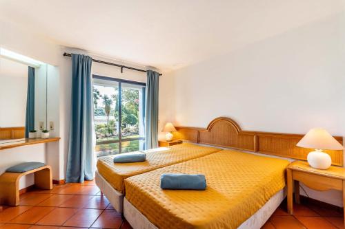 una camera con letto giallo e finestra di Casa N's ad Albufeira