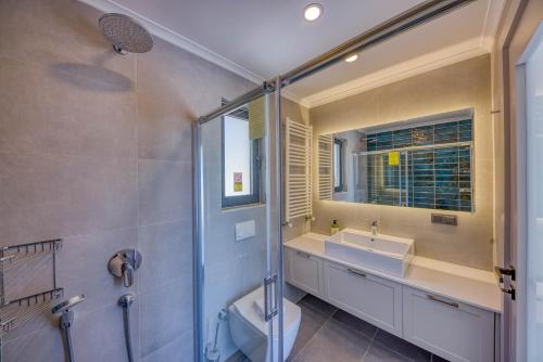 a bathroom with a shower and a toilet and a sink at Çukurbağ Köyü Doğa Manzaralı Villa Oriente in Kas