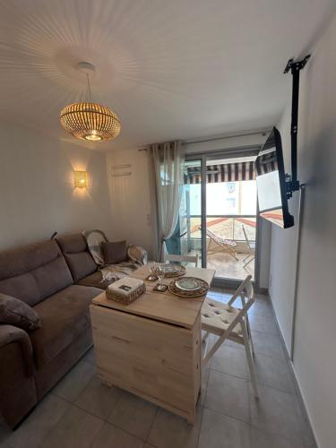 un salon avec un canapé et une table dans l'établissement Appartement cosy à 200 m de la mer, à Cagnes-sur-Mer