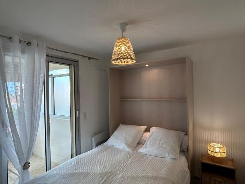 une chambre avec un lit et un lustre dans l'établissement Appartement cosy à 200 m de la mer, à Cagnes-sur-Mer