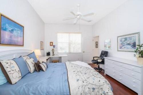 a bedroom with a large bed with a ceiling fan at Unique comfortable Golf course Home w Private Pool in Davenport